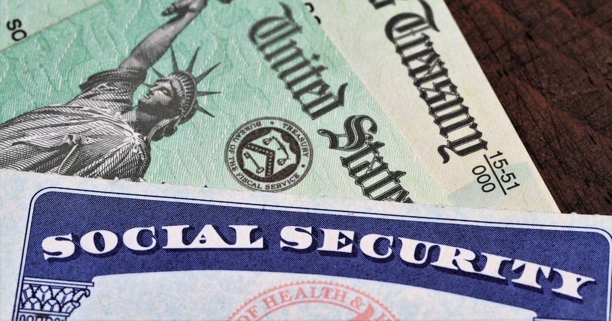 A Social Security card resting on United States Treasury benefit checks